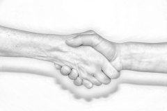 Auf dem Bild sieht man zwei Hände. Sie tauschen einen Händedruck aus. Das Bild ist in Schwarz-weiß gehalten. (©Peischer Landratsamt Bad Tölz-Wolfratsh