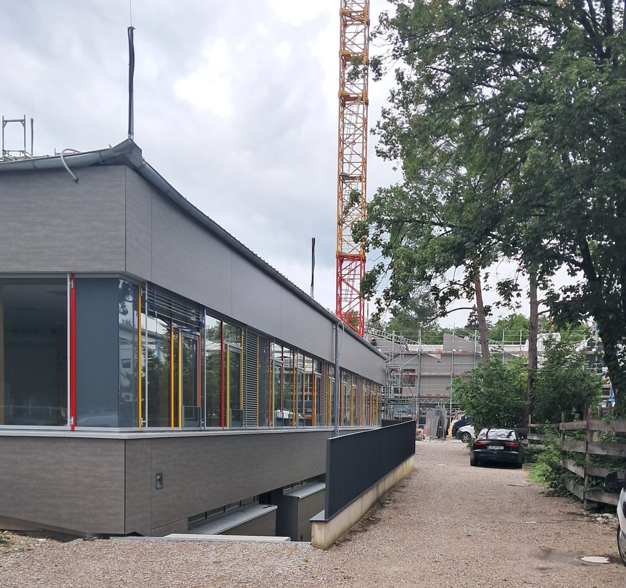 The construction site picture shows a part of the facade of the Geretsried school center. There is a crane in the background.