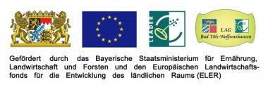 Der LEADER Förderhinweis besteht auf vier nebeneinander gereihten Flaggen bzw. Logos. Von Links nach rechts ist zuerst das Wappen des Freistaat Bayerns, dann die Flagge der europäischen Union, dann das LEADER Logo und zuletzt das Logo der LAG Bad Tölz-Wolfratshausen. Darunter steht in schwarzer Schrift "Gefördertu durch das Bayerische Staatsministerium für Ernährung, Landwirtschaft und Forsten und den Europäischen Landwirtschaftsfonds des ländlichen Raums (ELER)".