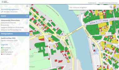 Der Screenshot zeigt eine interaktive Karte des Solarpotenzialkatasters für den Landkreis Bad Tölz-Wolfratshausen. Die Karte basiert auf OpenStreetMap (OSM) und bietet verschiedene Darstellungsoptionen, darunter eine alternative Farbvariante. Auf der linken Seite befindet sich ein Menü mit Optionen zur Anzeige des Solarpotenzials für Photovoltaik und Solarthermie, der Einstrahlung sowie der Eignung von Dachflächen für Solaranlagen. Zudem kann zwischen unterschiedlichen Hintergrundkarten wie einem digitalen Orthofoto gewechselt werden. Die Karte selbst zeigt eine farbcodierte Übersicht der Gebäude im Bereich rund um die Marktstraße und die Isar. Die Farben der Dächer entsprechen der Legende unten links: Grün: Gut geeignet Gelb: Geeignet Orange: Bedingt geeignet Rot: Nicht geeignet Im Zentrum der Karte befindet sich ein Kreisverkehr an der Marktstraße, die über eine Brücke die Isar überquert. Mehrere markierte Gebäude, darunter das Capitoltheater Bad Tölz und das Franziskanerkloster, sind sichtbar. Parkplätze und Fußwege entlang der Isar sind ebenfalls eingezeichnet. Oben rechts befindet sich eine Suchleiste zur Eingabe einer Adresse, um gezielt nach Standorten zu suchen.