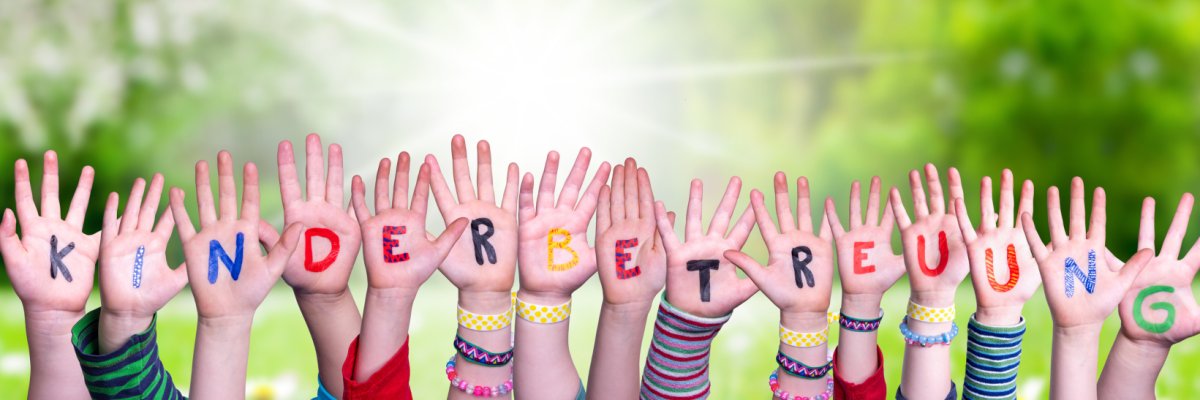 Against a green background, children's hands with the inscription "Kinderbetreuung" in colorful letters.