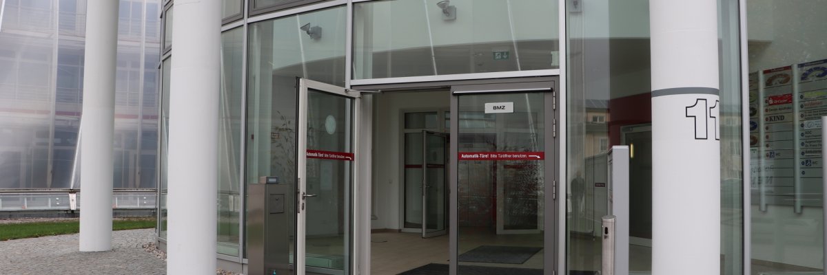 Entrance of the vehicle registration authority and driving license authority in the snail Photograph of the entrance door to the vehicle registration office in the Schnecke. The doors are open.