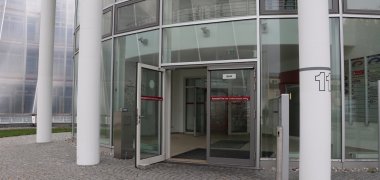 Photograph of the entrance door to the vehicle registration office in the Schnecke. The doors are open.