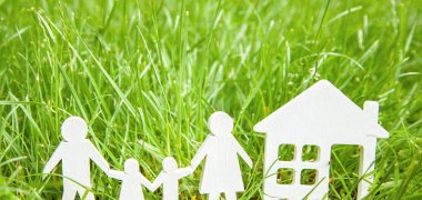 Papierfamilie und Haus auf Wiese Papierfamilie und Haus auf Wiese