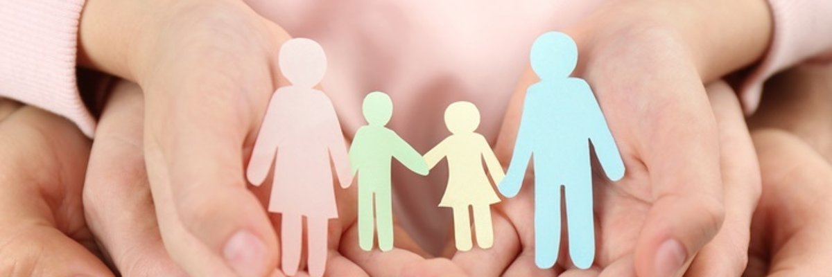 Familie in schützenden Händen Mehrere Hände halten gemeinsam viel Papierfiguren, die symbolisch eine Familie darstellen.