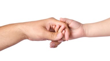 Father giving hand to a child Eine Kinderhand greift nach einer Hand von einem Erwachsenen. Verbundenheit und Fürsorge werden sichtbar.