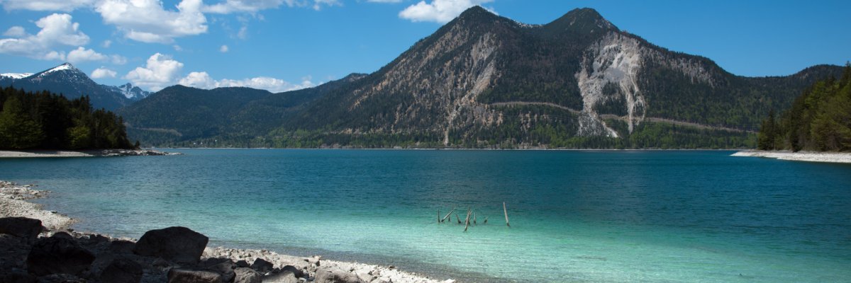 Walchensee in Oberbayern Aufnahme vom steinigen Walchenseeufer mit Blick über den See auf die Berge.